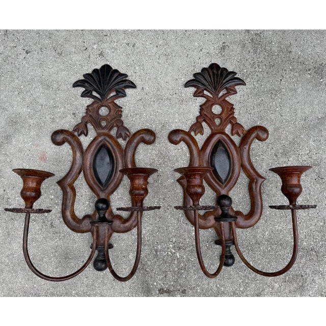 Pair of antique Spanish Revival cast iron wall sconces with a richly aged brown and black painted finish. Featuring...