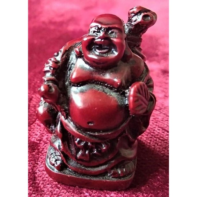 A striking miniature Laughing Buddha (Budai), exquisitely hand-carved from carnelian (red chalcedony) and finished to a...