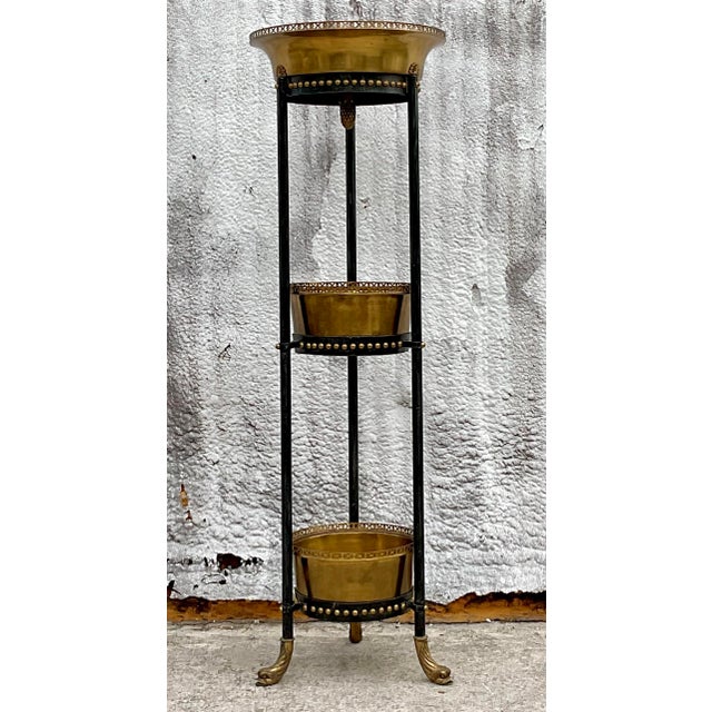 Add a touch of timeless elegance to your décor with this vintage Regency-style stacked brass planter by Theodore...