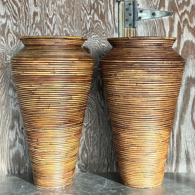 Elegant pair of vintage coastal pencil reed vases. Crafted with intricate reed detailing, these vases exude natural...