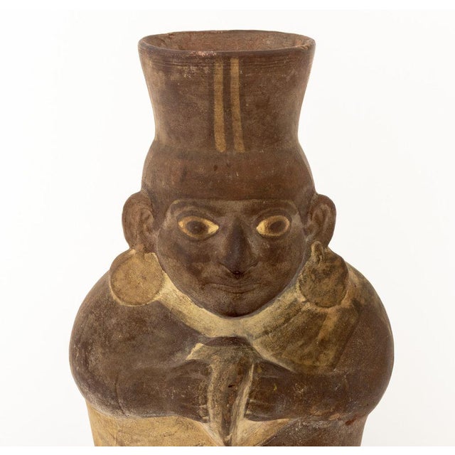 Moche Shaman Figure Pottery Vessel, the figure wearing a flared headdress and earrings, painted with three tones. 10.25" H...