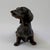 This charming bronze sculpture depicts a dachshund with its distinctive elongated body and alert expression. The sculptor...