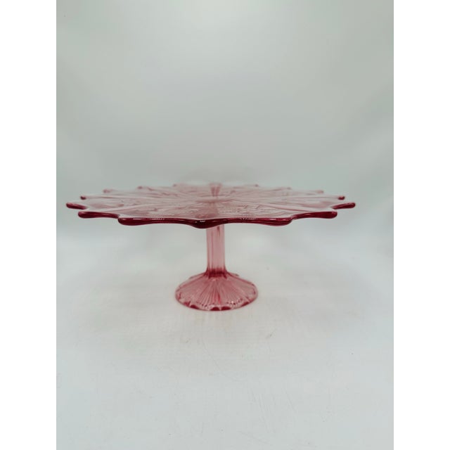 Vintage Pressed Glass Cake Stand (Cranberry Pink) Visual Design: • Color: A vibrant cranberry or deep pink glass with...