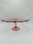 Vintage Pressed Glass Cake Stand (Cranberry Pink) Visual Design: • Color: A vibrant cranberry or deep pink glass with...