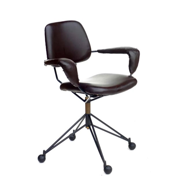 Iron and brass frame. Brown leatherette. Black rubber wheels. This piece has an attribution mark, I am sure that it is...