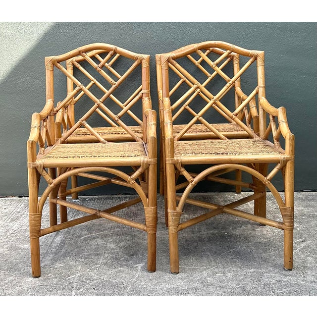 Elevate your dining space with this exceptional set of four vintage Chinese Chippendale style rattan armchairs. Expertly...