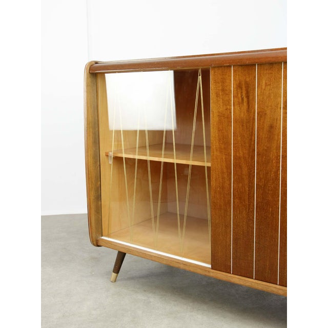 - Glossy finish - Golden ornaments (on glass and wood) - Used to store LP records and a record player (right side) as the...