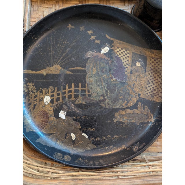 A beautifully composed set of antique Japanese black lacquerware presented in a woven wicker carrying basket. The...