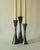 Three candleholders of varying heights, crafted from weathered steel and brushed in the central section to create a...