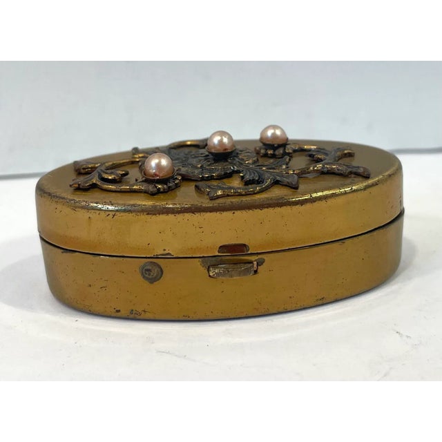 Cute little gold tone metal pillbox with floral beaded design on top