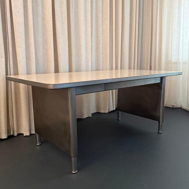 This sleek, industrial, brushed steel police station desk circa the 1950s is a handsome example of streamlined Mid-Century...