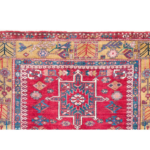 A striking early 20th century Persian Karaja rug with a tribal pattern containing three large central medallions heavily...