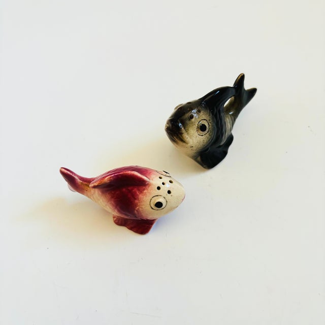 A pair of vintage ceramic salt and pepper shakers in the shape of fish, each with a removable cork stopper. Made in Japan....