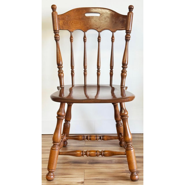 Vintage Ethan Allen Colonial maple and birch dining chairs featuring a spindle back with a contoured seat and turned legs...