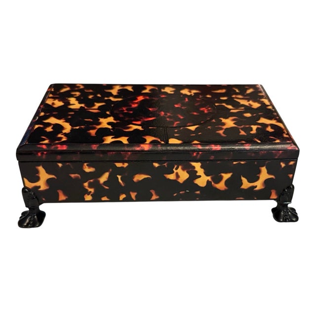 Faux tortoise shell rectangular box. Marbled paper interior. On decorative metal feet.