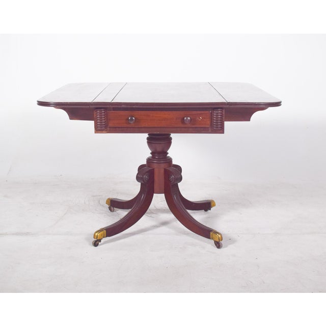 Side table with drawers. with a top that can be extended by means of two folding side flaps, the top has rounded contours...