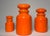 A bright, fluorescent orange colored paint with a glossy finish adorn this set of three, (3), vintage apothecary jars....