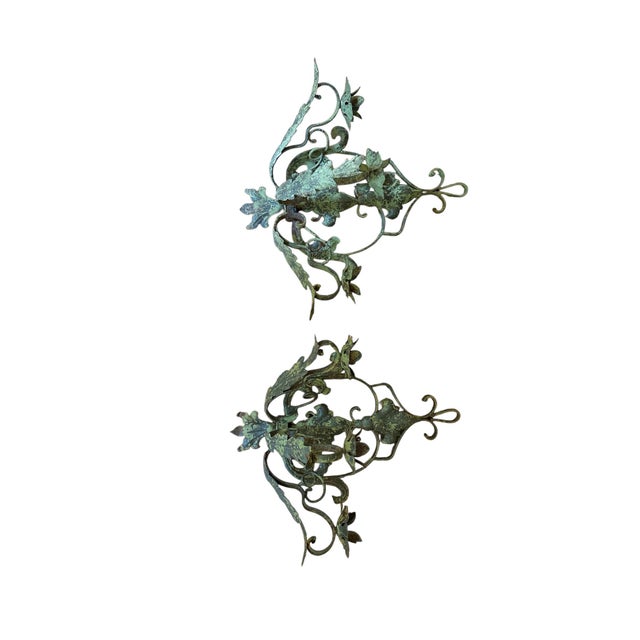 Decorative pair of iron garden sconces with distressed green paint. Double fleur de lis and scrollwork adds character to...
