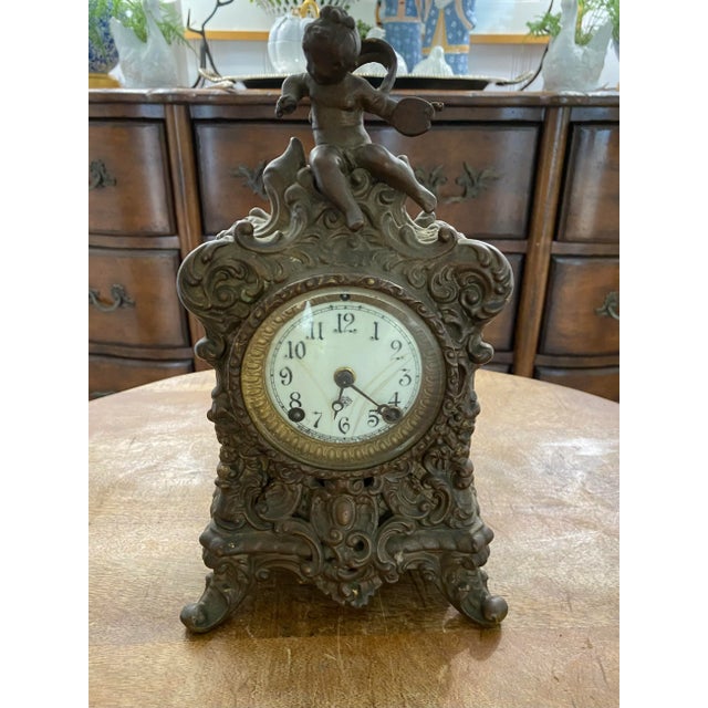 Beautiful antique Victorian clock with ornate cherub and floral decoration. Nicely-aged patina with a dark bronze...