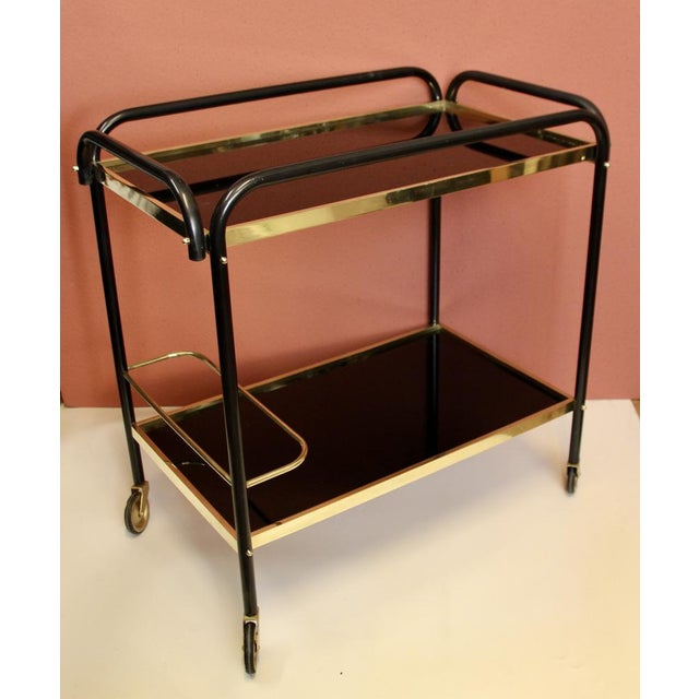 This elegant bar cart was made in France around 1940 and is made of solid brass profiles and black painted steel. It has a...