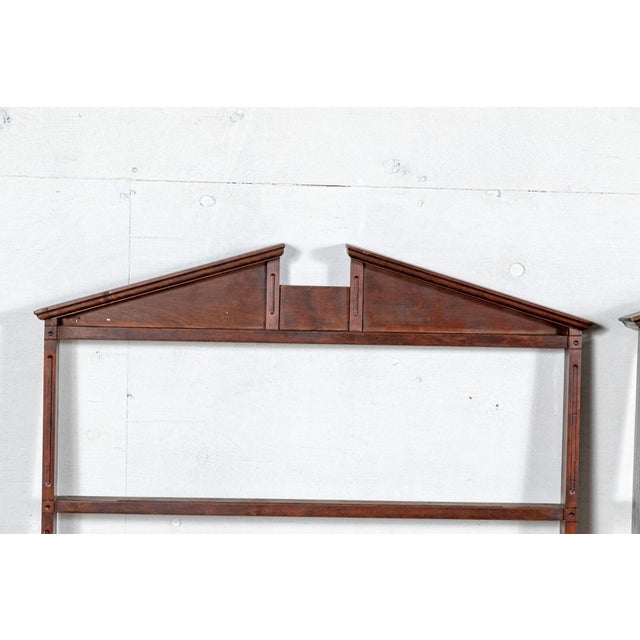 A complementary pair of tall, open wooden wall mounted plate racks with classical broken triangular pediments and four...