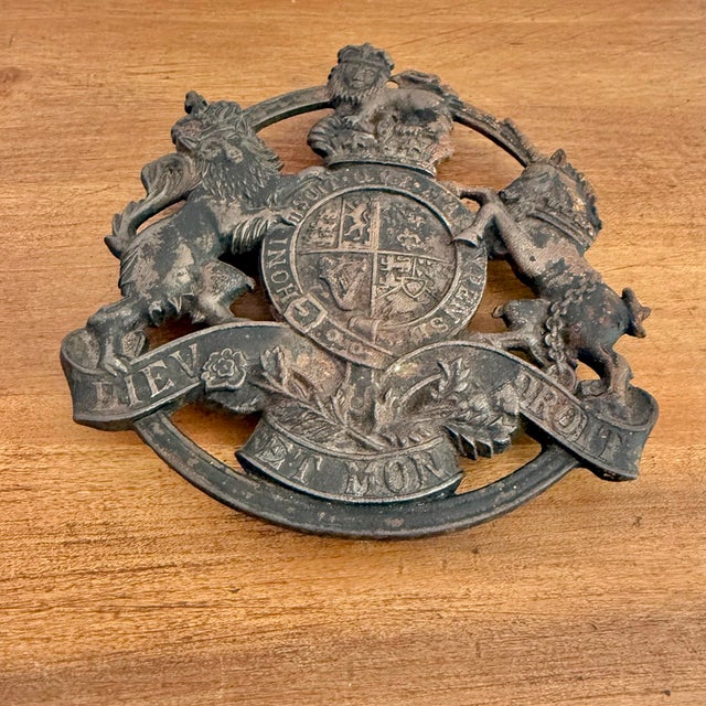 Vintage Virginia Metalcrafters cast iron trivet bearing the plaque of the Royal Arms of the United Kingdom. Please see...