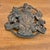 Vintage Virginia Metalcrafters cast iron trivet bearing the plaque of the Royal Arms of the United Kingdom. Please see...