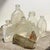 Collection of seven tiny vintage glass bottles in an assortment of shapes and sizes, originally used for cosmetics,...