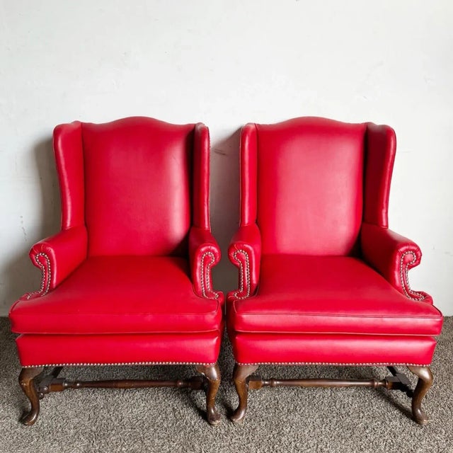 Elevate your home decor with the timeless elegance of the Traditional Red Faux Leather Wingback Chairs, offered as a pair....