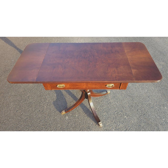 Newly refurbished Early 20th Century Georgian-style Walnut and Flame Walnut Veneer Sofa Table, featuring a central...