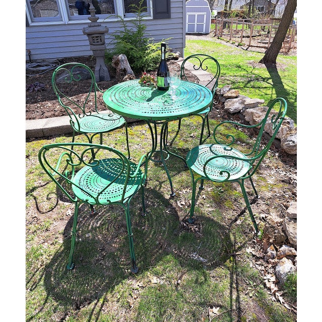 A fun and unusual wrought iron and steel plate bistro set bearing the Woodard label. The smaller size will fit into a...