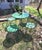 A fun and unusual wrought iron and steel plate bistro set bearing the Woodard label. The smaller size will fit into a...