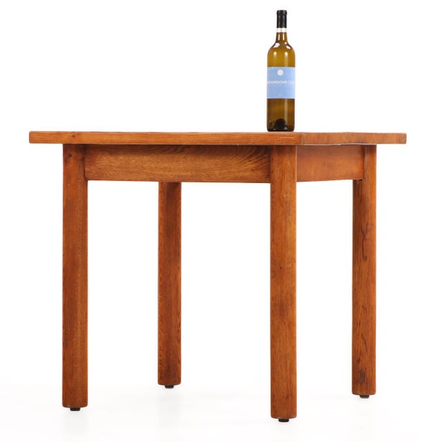 The substantial square top is supported by four boldly turned round oak legs, showcasing the sculptural simplicity and...