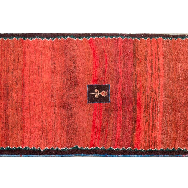 A wonderful mid-20th century Persian Gabbeh rug with a fantastic abrash crimson field with a small central floral...