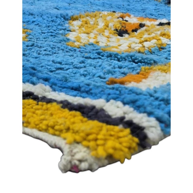 Boujad Rug | Handwoven Berber Wool Rug with Sky-Blue Field and Playful Tribal Symbols This lively Boujad rug features a...