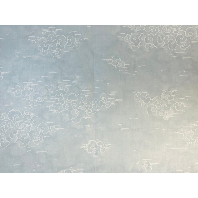 Fluffy Chinoiserie-inspired clouds gently float across a natural linen ground. The cloud motifs feature expressive, batik-...