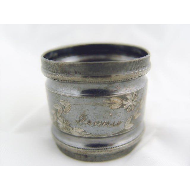 A pair of antique early 20th century silverplate napkin rings, engraved floral design with names Fannie and Abram....