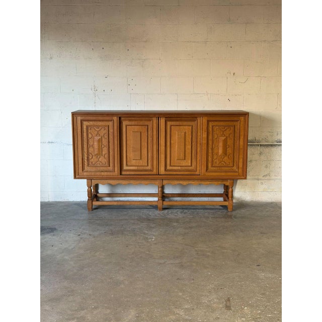This spacious storage piece features elegant paneled cabinet doors and an open base with turned supports. Crafted by...