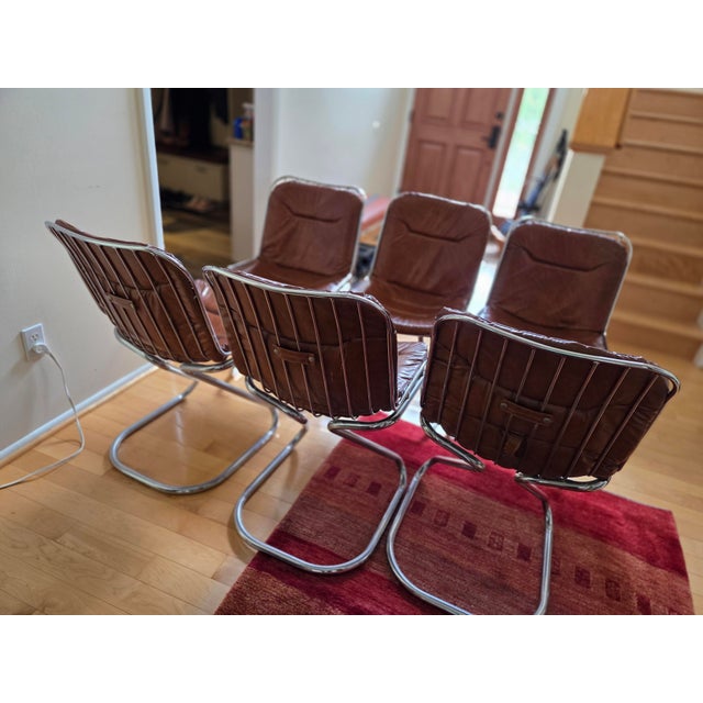 Set of six Mid-Century Modern Italian dining room chairs in cognac brown leatherette and polished chrome tubular framing.