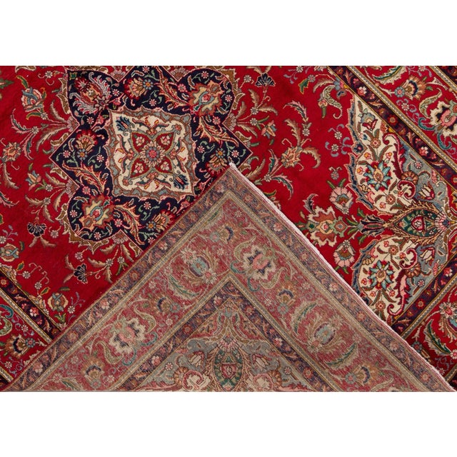 Beautiful vintage Persian Tabriz hand-knotted wool rug with a red field. This piece has a multi-color accent in an all-...