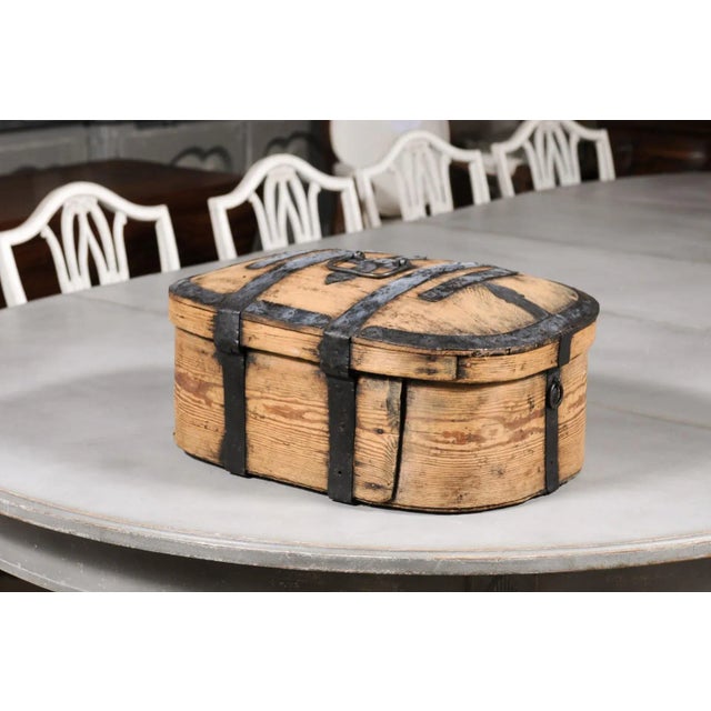 A rustic Swedish wooden box from the late 18th century, with iron accents and natural patina. Created in Sweden during the...