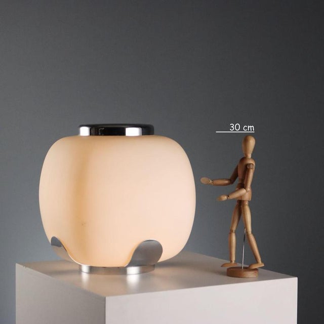 This Italian-made table lamp, reminiscent of Stilnovo products, features an opal glass diffuser and a chromed metal frame....