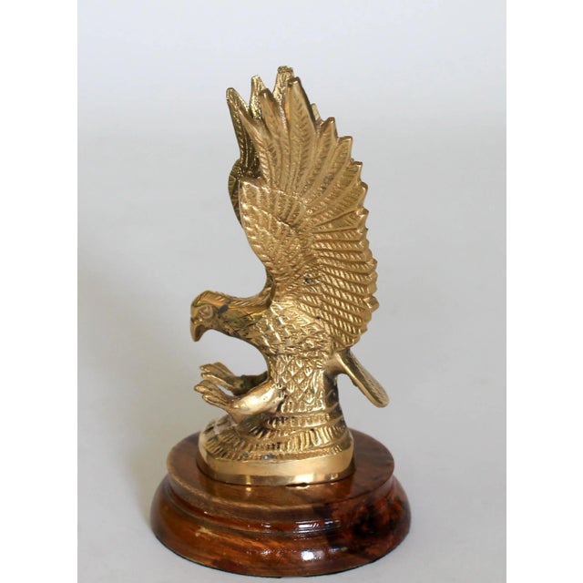 Vintage brass eagle sculpture on wood base. Marked "Made in India" on bottom. Some age wear to brass and wood.
