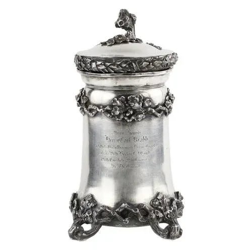 An impressive beer cup-mug made of 13 lott silver, cylindrical in shape on 4 legs, decorated with a pattern of oak...