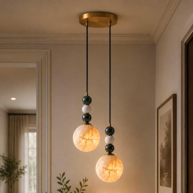 Add a warm sculptural presence to your interior with this handcrafted brass 2-light pendant featuring natural alabaster...