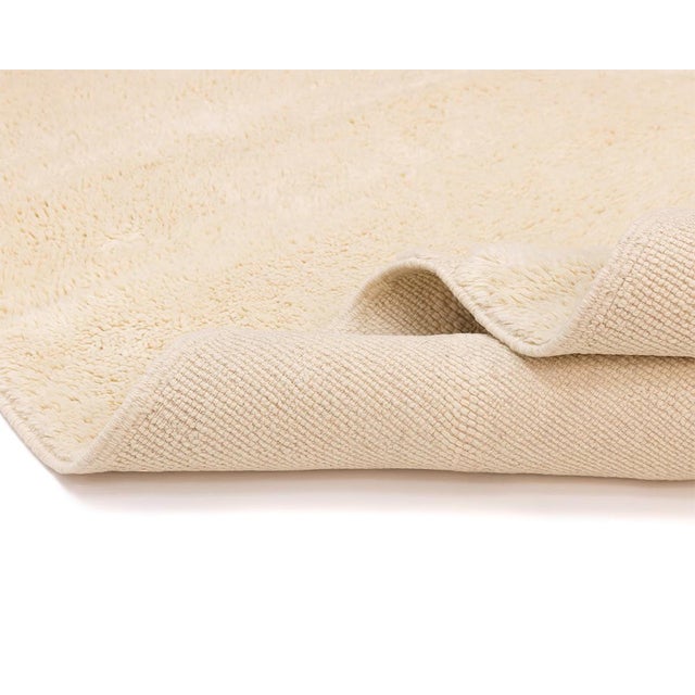 Elegant hand-knotted wool rug featuring a subtle handwoven geometric diamond pattern in Ivory tones, effortlessly...