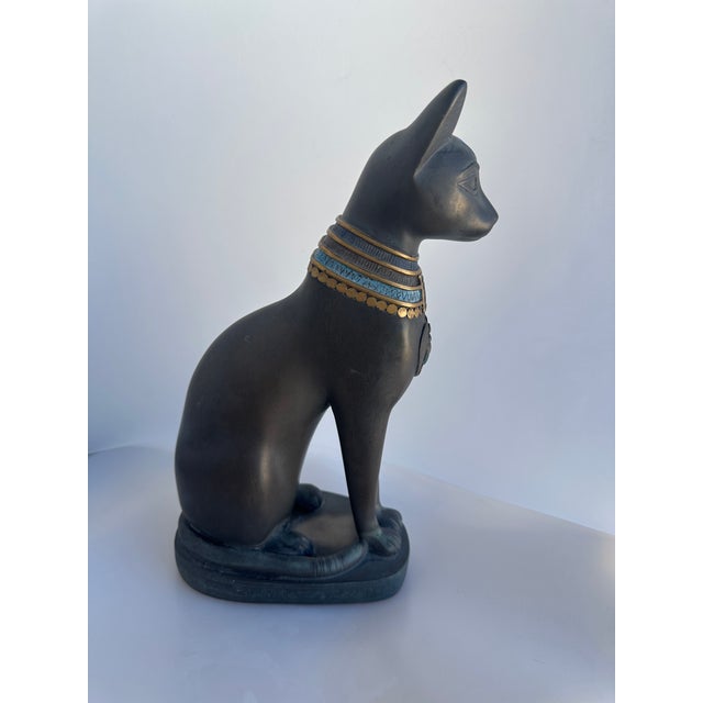 Egyptian Bastet Cat Figure in dark gray with gold, turquoise neck pattern. Great as a door stop or just as an art piece on...