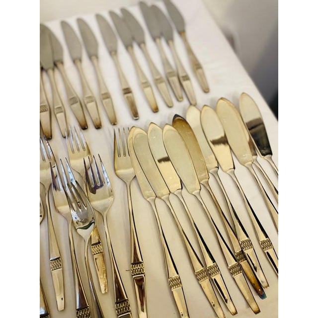 The large set comprises 97 parts: a trowel, 10 large forks, seven serving cutlery, 12 dessert spoons, 11 dessert knives,...