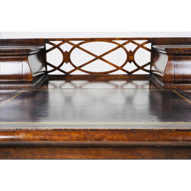 A refined English Georgian Revival kneehole desk, likely dating to the early 20th century, executed in richly grained...