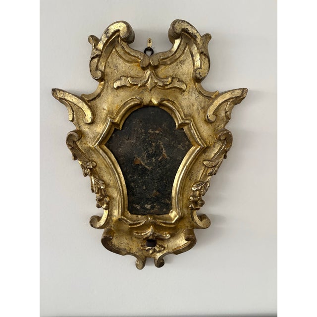 Pair of Italian giltwood mirrors, late 18th/ early 19th century in the Baroque taste. The shield-form mirrors with broken-...